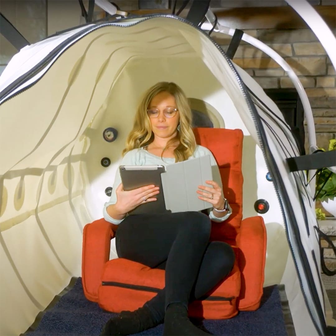 woman reading on her tablet in Hyperbaric Oxygen Chamber